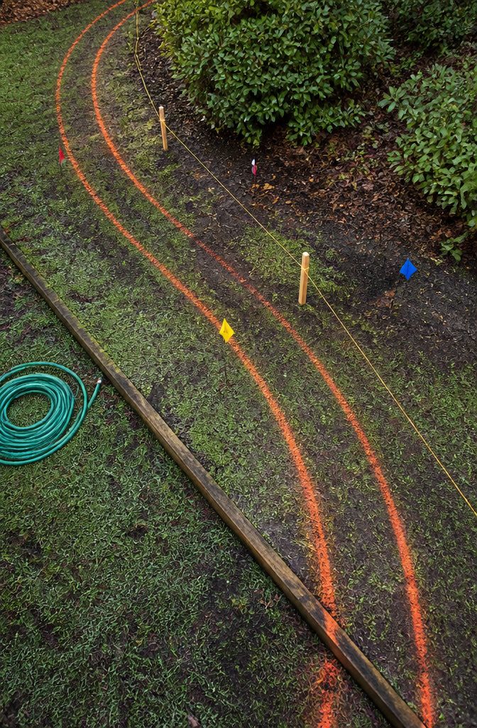 How to Build a Concrete Curb in 7 Steps 2 Spray-painted curb route marked across a yard with stakes
