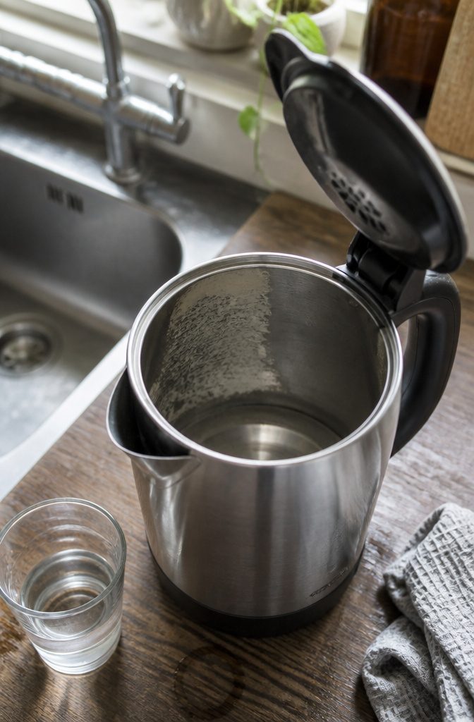 How to Clean an Electric Water Boiler in 6 Steps 2 Open stainless steel kettle with irregular white limescale and a clean patch inside