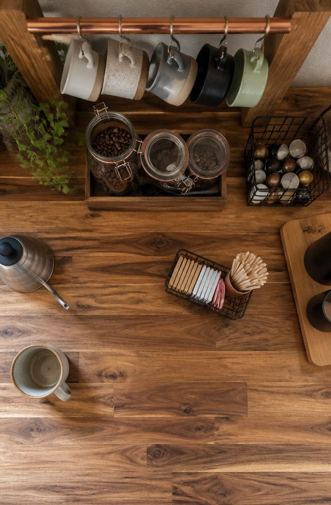 12 Ways to Make a Coffee Bar at Home 6 Coffee canisters and mugs stored on shelves beside a copper pipe mug rack