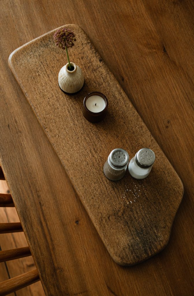 Kitchen table with a tray holding salt and pepper shakers a vase and candle
